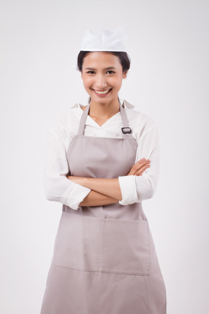 happy smiling confident professional asian woman domestic worker, domestic helper, woman housekeeper, girl shopkeeper, housewife, girl cleaner, woman maid, girl cleaning service staff studio portraitの写真素材