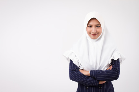 confident happy smiling muslim business woman; studio portrait of islamic business woman with hijab, head scarf; asian businesswoman, female business person crossing arms; asian girl adult modelの写真素材