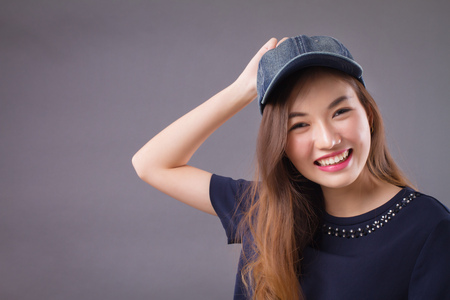 happy asian girl with smiling woman face; portrait of happy, smiling, joyful, cheerful asian woman in casual dress studio isolated; asian chinese young adult woman modelの写真素材