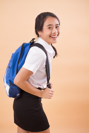 asian thai college woman student; education theme portrait of university woman student carrying textbook backpack; concept of college education, university education; asian young adult woman modelの写真素材