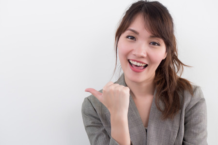 happy smiling woman giving thumb up; positive excited happy smiling successful asian showing approving, accepting, good job, yes, ok thumb up gesture; asian chinese woman adult modelの写真素材