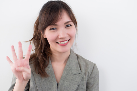 asian business woman pointing four fingers, 4 points; portrait of positive happy smiling asian businesswoman pointing up four fingers, 4 points number; asian chinese adult woman model business themeの写真素材