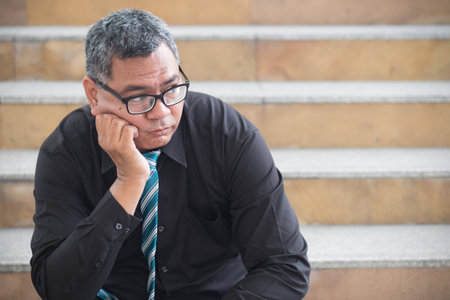 unemployed old asian business man. portrait of businessman suffering from layoff, economic recession, business crisis, unemployment, bankruptcy or business depression. asian 50s old man model.の写真素材