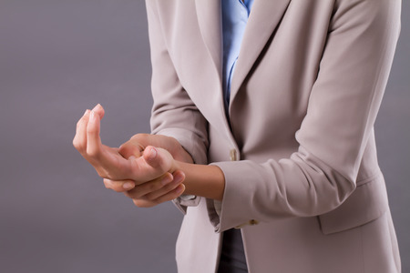 woman suffering from trigger finger, cps, wrist joint pain, arthritis, gout; joint care in clinic or hospital, health, medical concept; tan skin asian woman modelの写真素材