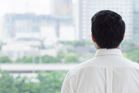 business man looking through office windowの写真素材