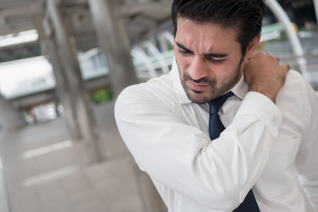 Sick unhealthy asian man suffering from shoulder pain, stiff shoulder, arthritis, gout, office syndromeの写真素材