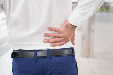 Sick unhealthy asian man suffering from back pain, spine problem, hernicated disc, spinal disc...