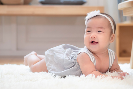 cute happy healthy laughing baby crawling on home floorの写真素材
