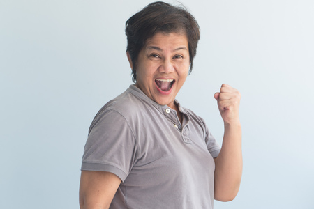 happy, laughing, confident, strong middle aged woman shouting with joyの写真素材