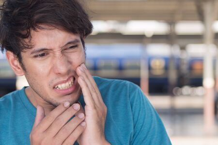 man suffering from toothache, tooth decay, tooth sensivity; oral health care conceptの写真素材