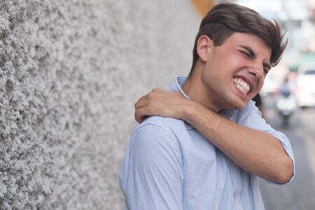 man suffer from stiff shoulder, muscle inflammationの写真素材