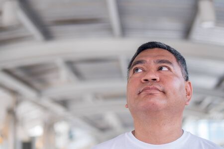 old man thinking, asian senior looking upの写真素材