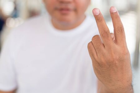 angry old man showing rude, vulgar v sign hand gestureの写真素材