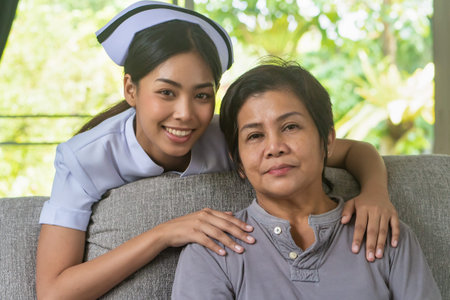 asian nurse with old woman or senior pensioner; concept of home nursing, senior care giving