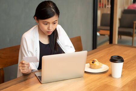 excited happy asian business woman with credit card, small startup business owner working with laptop computer; concept of small business, electronic payment, e-payment, digital money wallet or purseの写真素材