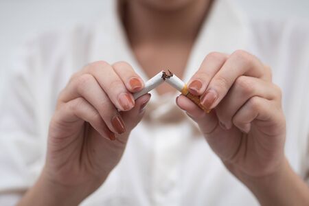woman breaking cigarette to quit smoking; smoking ban or no smoking conceptの写真素材