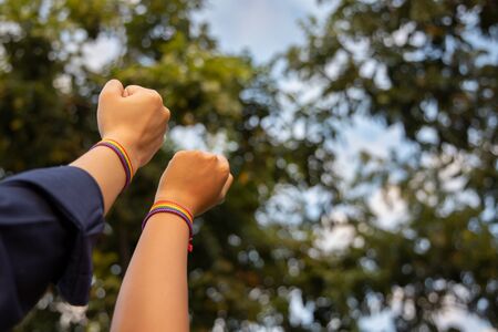 hand of LGBT women holding together with rainbow ribbon symbol; concept of LGBT pride, LGBTQ people, lgbt rights campaign, same sex marriageの写真素材