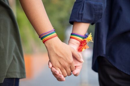 hand of LGBT women holding together with rainbow ribbon symbol; concept of LGBT pride, LGBTQ people, lgbt rights campaign, same sex marriageの写真素材