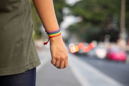confident LGBT woman showing rainbow ribbon symbol; concept of LGBT pride, LGBTQ people, lgbt rights campaign, equality, same sex marriage, sex preference diversity in modern societyの写真素材