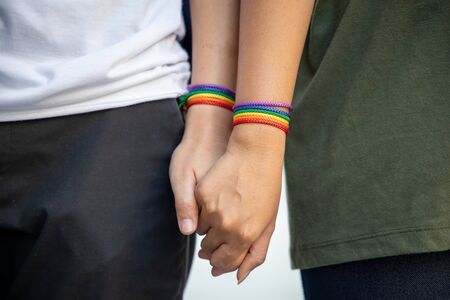 hand of LGBT women holding together with rainbow ribbon symbol; concept of LGBT pride, LGBTQ people, lgbt rights campaign, same sex marriageの写真素材