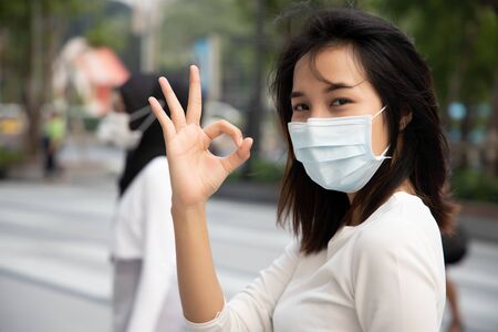 sick woman wearing mask, stopping virus outbreak; concept of biohazard, biological hazard, preventive health care, disease quarantine, coronavirus outbreak control, sickness containment, health careの写真素材