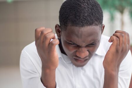 angry frustrated black African businessman, worker, employee with very serious emotion expressionの写真素材