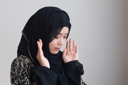 Muslim woman in hijab & middle eastern dress praying with islamic faith; concept of Muslimah, Namaz...