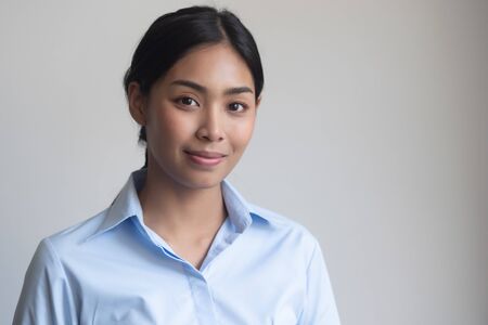 face portrait of happy smiling girl; portrait of positive relaxed happy smiling asian woman smiles on isolated background; young adult southeast asian woman modelの写真素材