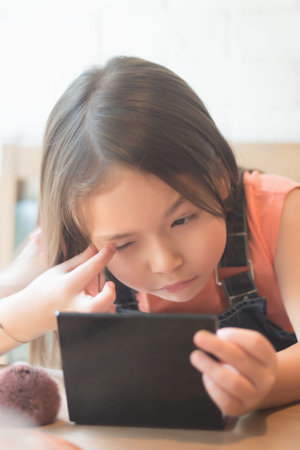 cute little girl playing and applying makeup cosmetics to her face; concept of girl grooming, face care, beauty face, kid playing with cosmetics; asian caucasian kid girl modelの写真素材