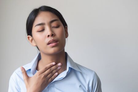 sick woman with sore throat portrait; sick woman with sore throat, cold, flu, contagious disease, cold or flu spreading, virus outbreak, coronavirus, COVID 19, pandemic, endemic health care conceptの写真素材