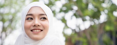 Banner of Happy smiling muslim woman looking away in modern cityの写真素材