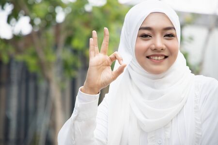 Happy smiling muslim woman showing ok hand gestureの写真素材