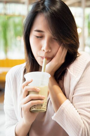 happy young asian woman drinking boba milk tea, bubble milk tea, pearl milk teaの写真素材