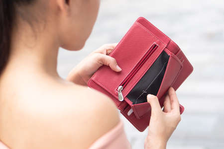 poor woman without money, empty wallet; portrait of poor woman with empty wallet, poor people, poverty, bankruptcy, economic recession, depression, unemployment, concept; asian young adult woman modelの写真素材