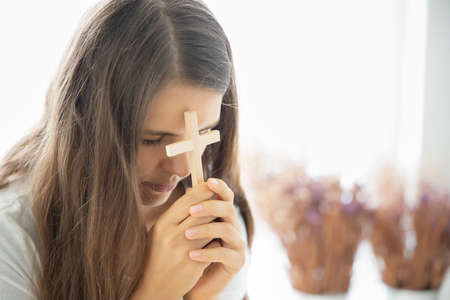religious christian woman disciple praying to god with holy crossの写真素材