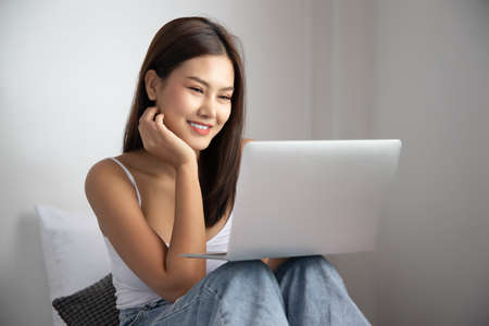 bored unhappy woman working at home with laptop computer; concept of video call, VDO conference, telemedicine videocall, working at home, new normal social distancing precautionの写真素材