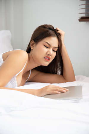 bored unhappy woman working at home with laptop computer; concept of video call, VDO conference, telemedicine videocall, working at home, new normal social distancing precautionの写真素材