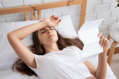 frustrated, shocked, stressed women with expensive bill, debt invoice, eviction notice; concept of high cost of living, expensive bill, getting busted, economic recession, no job no moneyの写真素材