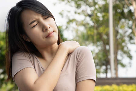 Asian woman scratching her arm skin; concept of dry skin, allergic skin inflammation, body care, fungus inflammation, dermatology disease, eczema, rash, skin care; young adult asian woman modelの写真素材