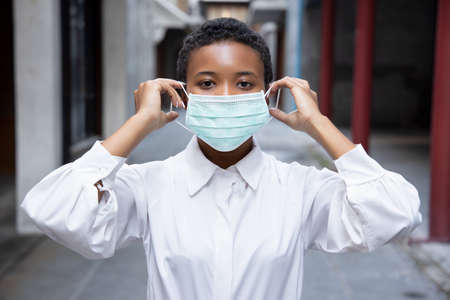 Muslim woman suggesting to wear face mask in outdoor public; concept of new normal lifestyle, social distancing, flatten the curve, preventive measure against flu pandemicの写真素材