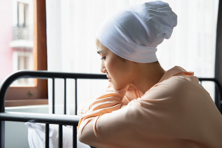 Portrait of sad asian woman cancer patient wearing head scarf after suffering serious hair loss due...