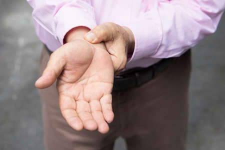 Old senior man suffering from trigger fingerの写真素材