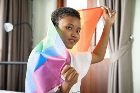 Black African LGBT woman holding LGBTQ rainbow flag, lesbian pride or LGBT pride movement, inclusivity, diversity of people conceptの写真素材