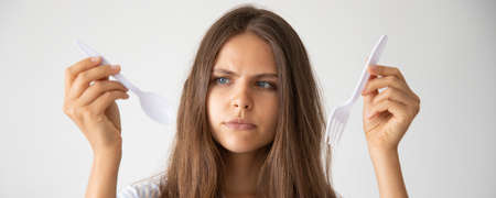 unhappy woman with single use plastic cutlery, recycle concept, banner formatの写真素材