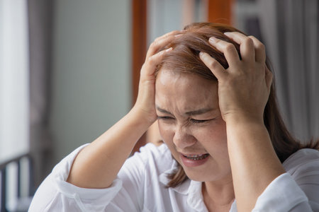 sick asian middle aged woman suffering from headache; health and sickness concept for vertigo...