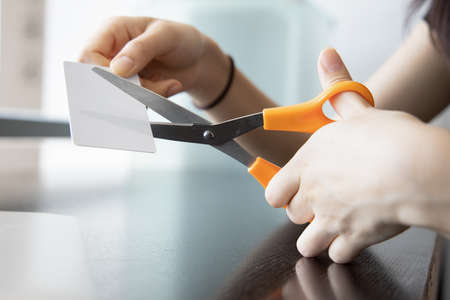 woman cutting credit card, concept of financial problem, no money, overspending, economic recession, depression, scammer, credit fraud, running out of credit, expense cutの写真素材