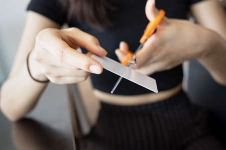 woman cutting credit card, concept of financial problem, no money, overspending, economic recession, depression, scammer, credit fraud, running out of credit, expense cutの写真素材