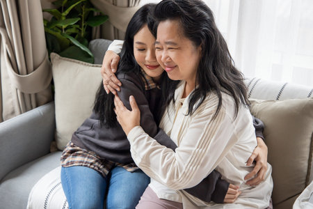 Lovely asian senior mother and young daughter talking, chatting, consulting together with happy...