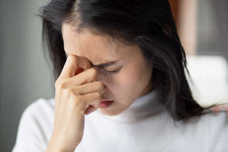 sick asian woman with indigestion problem, acid reflux or gerd symptoms; woman health care, body care, sickness, pain, acid reflux, pneumonia, virus disease conceptの写真素材