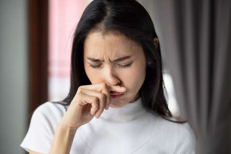 sick asian woman with indigestion problem, acid reflux or gerd symptoms; woman health care, body care, sickness, pain, acid reflux, pneumonia, virus disease conceptの写真素材